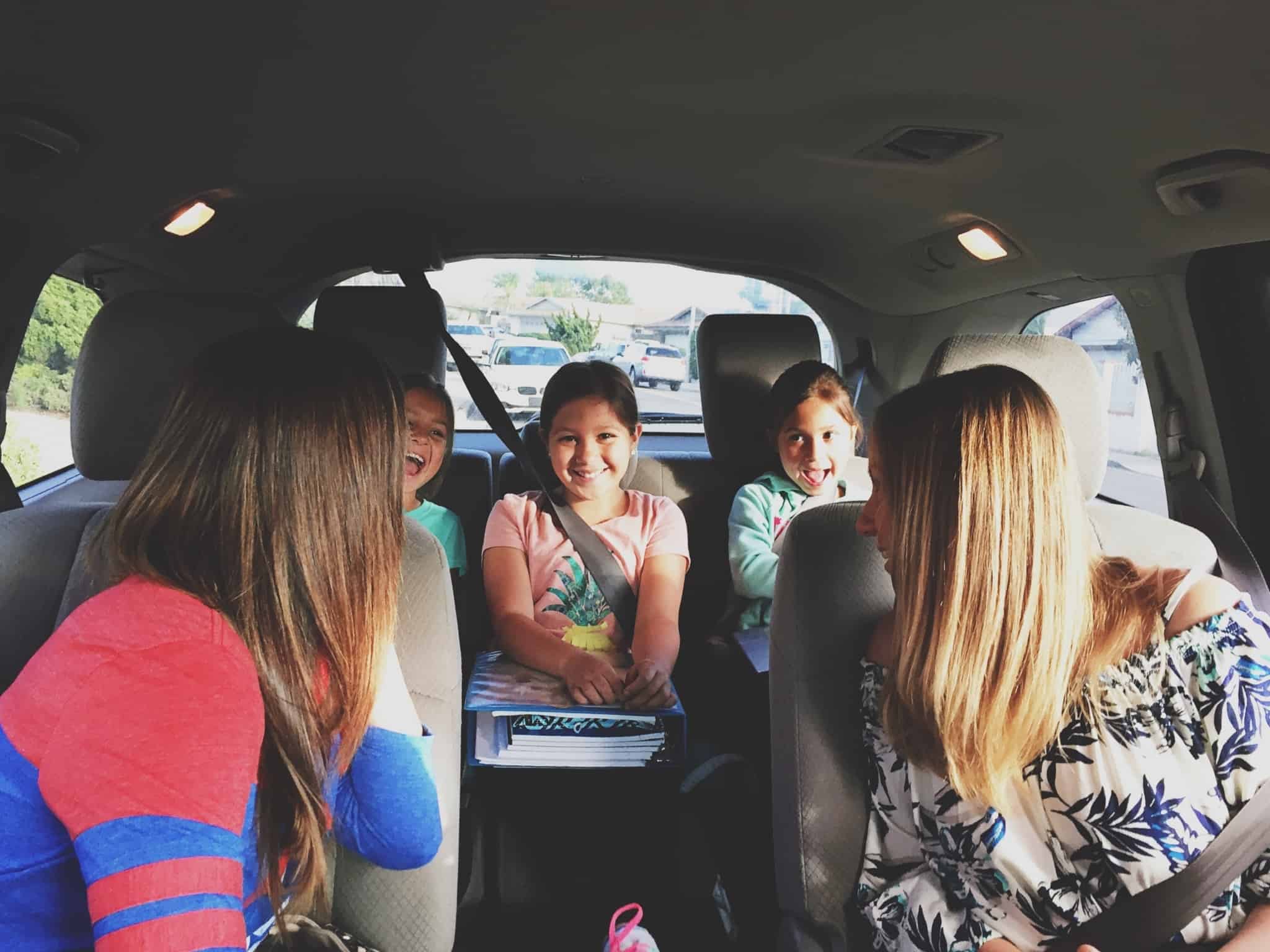 carro familiar com duas mulheres a frente e três crianças
