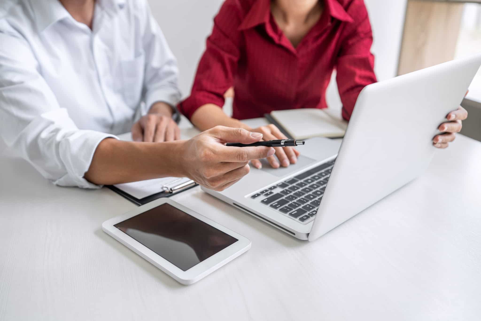 duas pessoas a negociar com um computador a frente