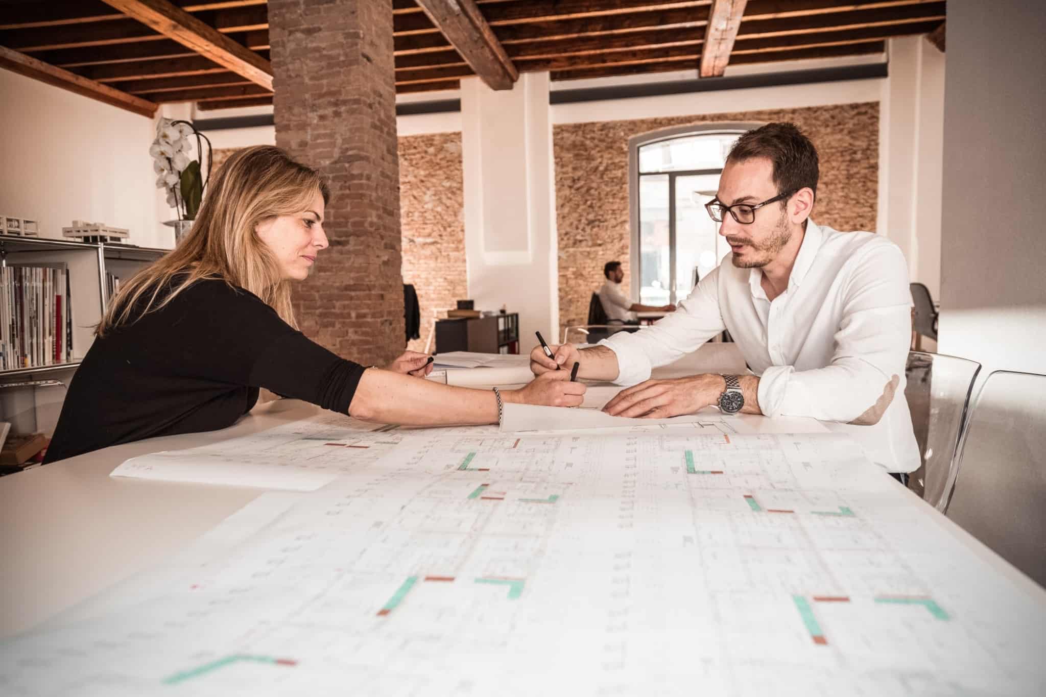dois arquitectos a trabalhar num projecto em cima de uma mesa