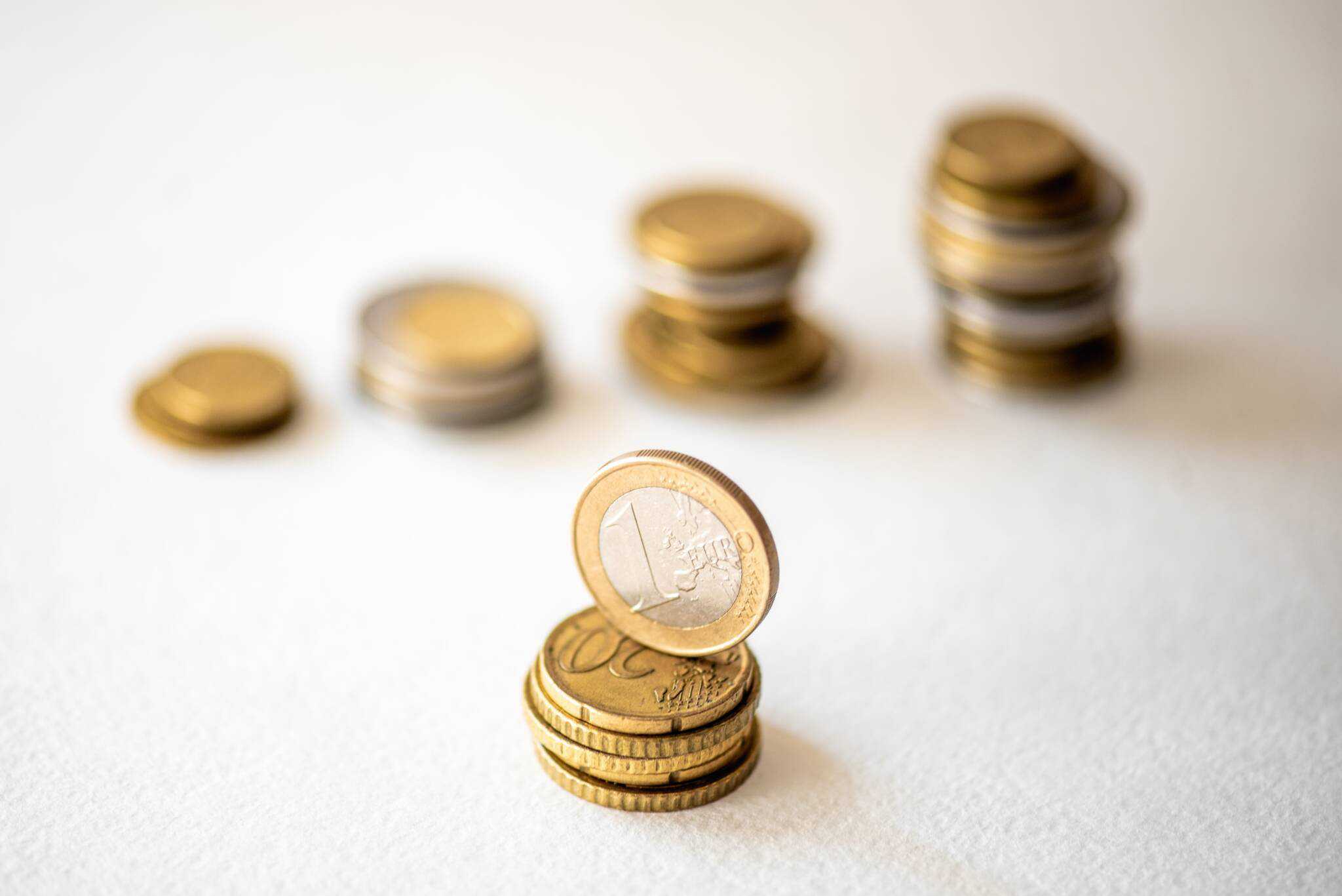 moedas de um euro frente a várias pilhas de moedas que vão crescendo, à media que se aumenta a popuança e se consegue construir fundo de emergência